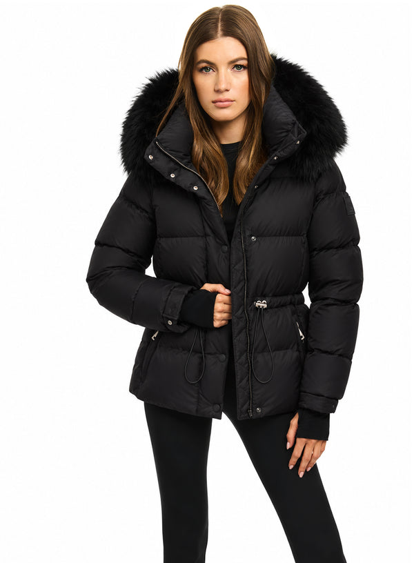 DELANEY A woman modeling a black puffer jacket with a large black fur-trimmed hood, shown against a plain white studio background.