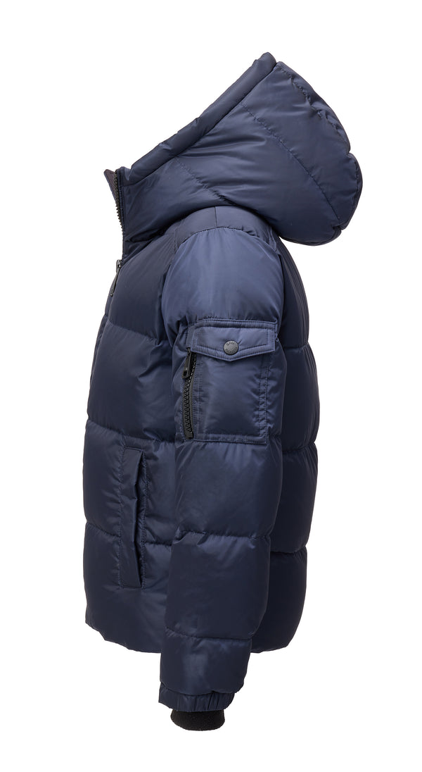 TODDLER BOYS PARKER navy puffer jacket from the side with the hood down featuring a pocket on the arm with a zipper and a snap against a white background